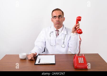 Mature Persian man doctor working behind desk Stock Photo