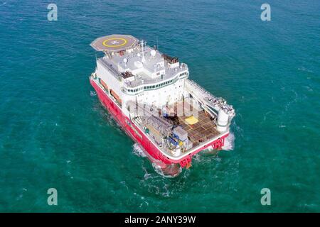 Large Platform supply ship with Helipad and two large cranes, anchored at Sea, Aerial view. Stock Photo