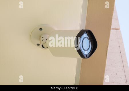 Modern CCTV camera mounted on a building wall or ceiling for outdoors surveillance, monitoring streets, homes or offices Stock Photo