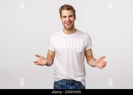 Man extending hands forward to hold something, leaning to product, helping out friend carry heavy boxes, smiling joyfully, friendly looking forward Stock Photo