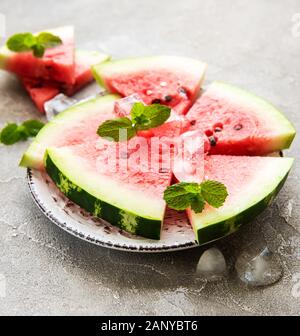 Watermelon with ice on a concrete background Stock Photo - Alamy