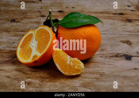 Oranges with leaves on the weathered wooden surface. Stock Photo