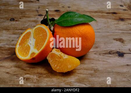 Oranges with leaves on the weathered wooden surface. Stock Photo
