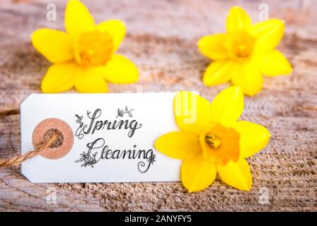One White Label WIth English Calligraphy Spring Cleaning. Yellow Tulip Spring Flower Blossom On Wooden Background Stock Photo