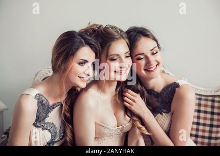 happy bride with her two friends sitting on the couch . Stock Photo