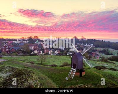 The sun rises over the village of Brill near Aylesbury in Buckinghamshire. The Grade II* listed windmill dates back to the 17th century. Stock Photo