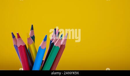 School, drawing, creativity concept. Colored pencils on yellow background. Copy space Stock Photo