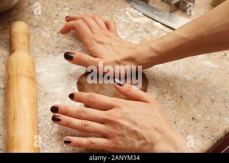Female cook preparing the dough to make cookies in a kitchen Stock Photo
