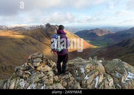 Walker Enjoying the View over Great Langdale and the Langdale Pikes from the East Top of Rossett Pike, Lake District, Cumbria, UK Stock Photo