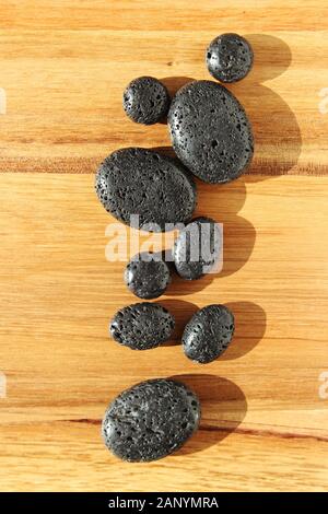 Wooden surface with black lava beads in a spa salon - great for background or wallpaper Stock Photo
