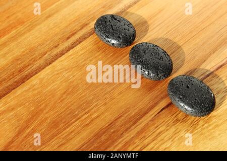 Wooden surface with black lava beads in a spa salon - great for background or wallpaper Stock Photo