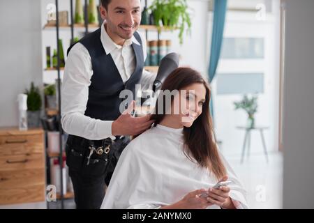 Hairstylist drying woman's hair Stock Photo