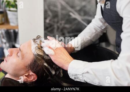 Close up of hairdresser washing man’s hair Stock Photo