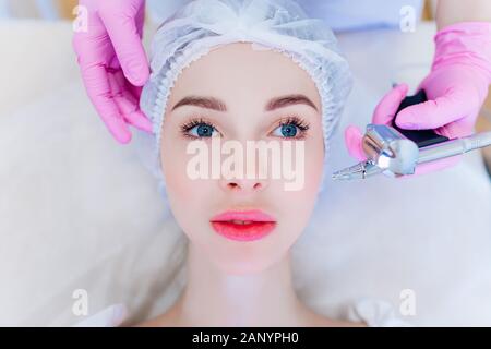 Hardware skin care. A young girl cares for her face. Beauty treatment. Procedures. Advertising. Stock Photo