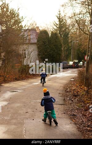 POZNAN, POLAND - Jan 12, 2020: Two boys riding a bike in the Debiec park. Stock Photo