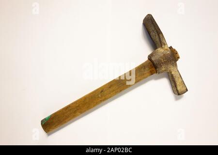 Miner hammer like pickaxe or mattock on white isolated background with shadow. Closeup view of rustic old hand tool for hard working to extract fossil Stock Photo