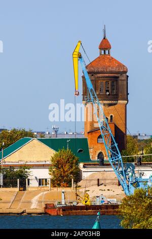 Old water-tower in river harbor. Port crane. Stock Photo