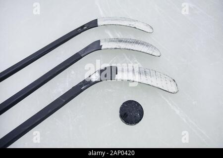 Top view background of hockey sticks and pluck laid out on ice, copy space Stock Photo