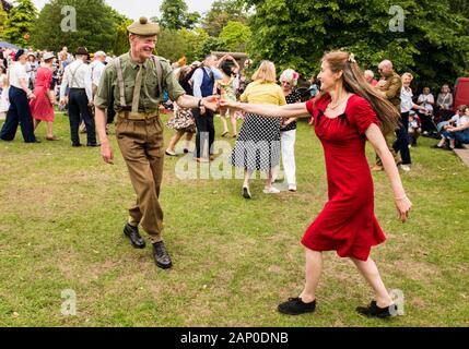 Couple swing dancing in authentic 1940s outfits in Valley Gardens on 1940s Day in Harrogate in England. Stock Photo
