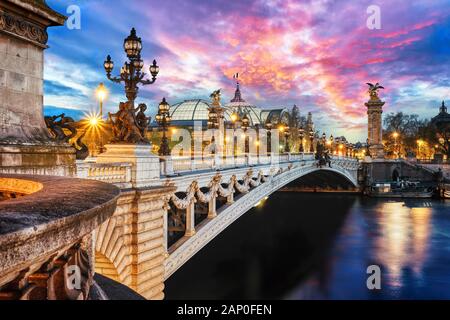 The Alexander III Bridge across Seine river in Paris, France at sunset.
