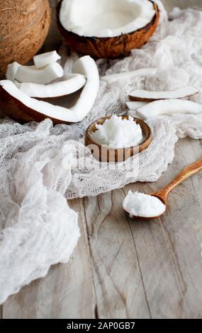 Coconut oil in a wooden bowl with a wooden spoon close up Stock Photo