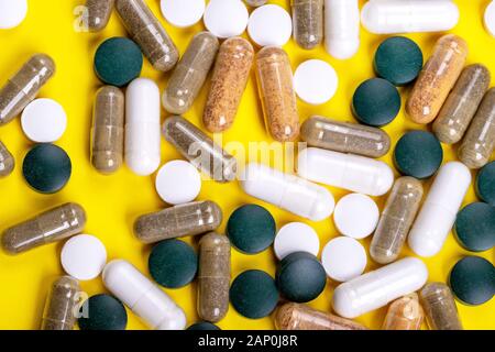 Different tablets on yellow background, top view, medicine concept Stock Photo