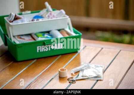 First aid kit on the table in the garden, green box Stock Photo