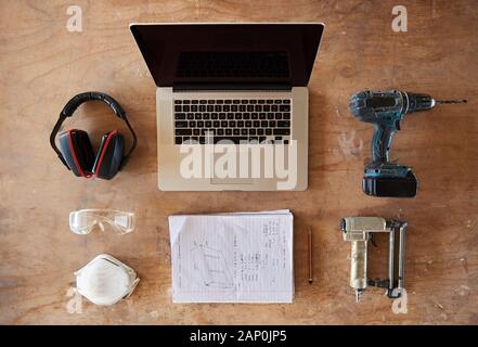 Laptop, plans and tools on a woodworking shop table Stock Photo