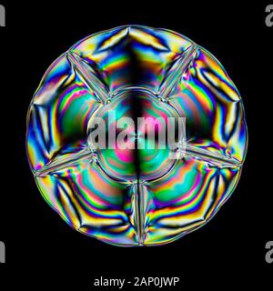 Colourful stress patterns in hard plastic, revealed by imaging between two crossed polarising filters showing colorful patterns in a serving dish. Stock Photo