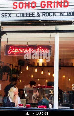 Two young women having coffee inside the Soho Grind espresso and cocktail bar in Soho. Stock Photo