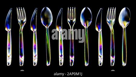 Colourful stress patterns in hard plastic, revealed by imaging between two crossed polarising filters showing a collection of plastcic cutlery. Stock Photo