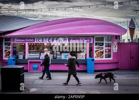 Pink and Blue Ice Cream Kiosk on a Winters Day with no Customers and People walking Past Stock Photo