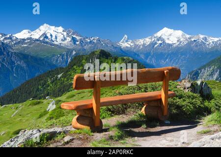Swiss Alps: Wooden bench with the Mischabel group, the Matterhorn and the Weisshorn in the background. Valais, Switzerland Stock Photo