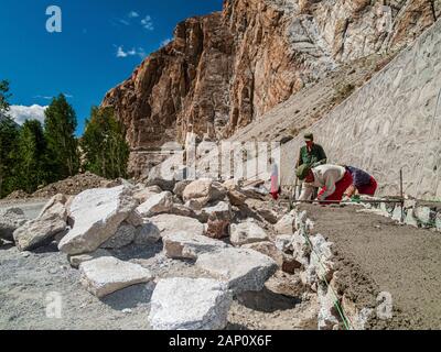 Road construction at Karakorum Highway by chinese workers, building a rock wall Stock Photo