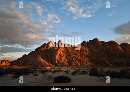 Morning light mood shortly after sunrise in the Spitzkoppeggebiet, taken on 03.03.2019. The Spitzkoppe region and the surrounding side peaks with their rock formations belong to one of the landmarks of Namibia, it rises to a height of 1728 meters above sea level. A paradise for climbers and hikers, the area is 120 kilometers northwest of Swakopmund and is sometimes difficult to reach. The formation, which was visible from afar, was created 100 million years ago by volcanic activity, which eroded softer cover rock, so that today only the harder granite rock can be seen in its bizarre forms. Pho Stock Photo