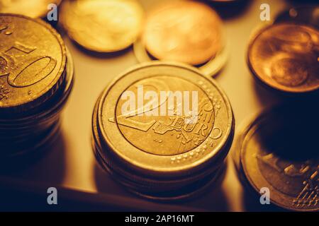 Stacks of iron euro coins on the dark table. Stock Photo