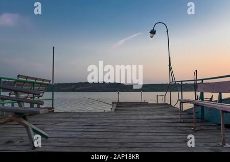 Wooden pier on the lake at sunset. Stock Photo