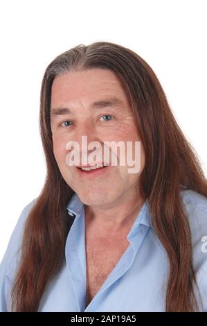 A handsome indigenous man smiling in a portrait shoot with his long brunette hair, isolated for white background Stock Photo