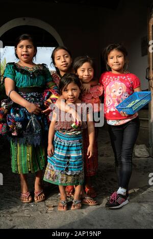Group shot of native, local children in Antigua, Guatemala. Some are wearing traditional outfit, some are selling hand-made souvenirs. Dec 2018 Stock Photo