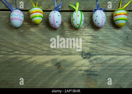 Colorful Easter eggs wit ribbon on a wooden background. Copy space beneath, Top view Stock Photo