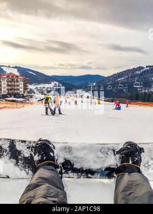 snowboarding concept sitting on the hill people skiing down Stock Photo