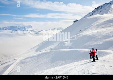 Skiers looking down the slope at Sella Ronda ski route in Italy Stock Photo