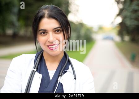 Young mexican female medic in uniform holding clipboard in doctor's ...