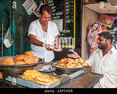 A vendor is selling delicious snacks in the street bazaar Stock Photo