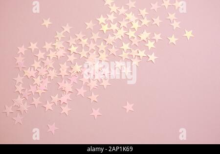 Pink background with pastel star shape confetti sparkles. Perfect festive background. Stock Photo