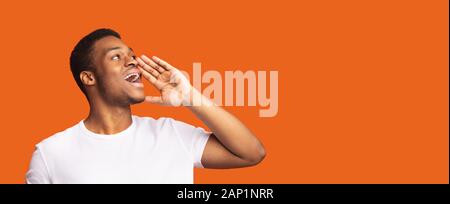 Afro guy portrait screaming on orange background Stock Photo