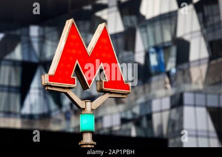 The letter "M" the symbol of the Moscow metro transport system on the background of the facade of an office building of modern design Stock Photo