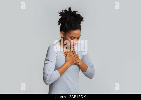 Sad young woman suffering from acute pain in chest Stock Photo