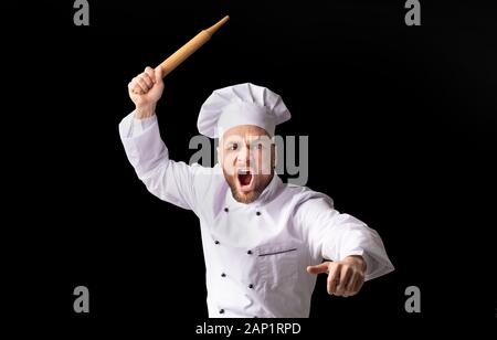 Angry Chef Bakerman Raising Rolling Pin Threateningly, Studio Shot Stock Photo