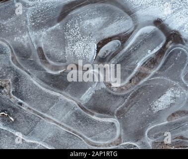 Abstract image of crack pattern in frozen puddle. Stock Photo